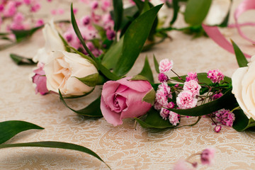 Ready-made wedding wreath for the bride from fresh flowers   of cream and pink roses,gypsophila and Ruskus leaves.Selective focus,close up