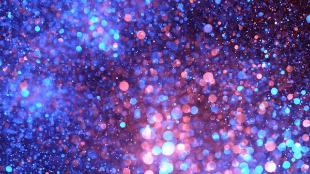 Super slow motion of glittering coloured particles on black background. Shallow depth of focus. Filmed on high speed cinema camera, 1000 fps.