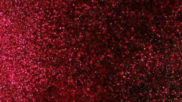 Super slow motion of glittering coloured particles on black background. Shallow depth of focus. Filmed on high speed cinema camera, 1000 fps.