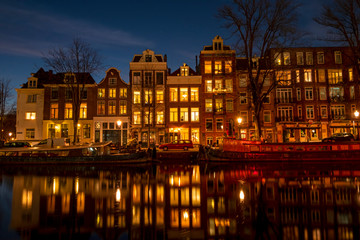 City scenic from Amsterdam at the Amstel in the Netherlands at night