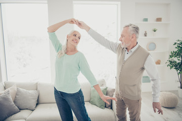 Portrait of sweet spouses looking wearing jeans trousers teal brown pullovers moving in big room