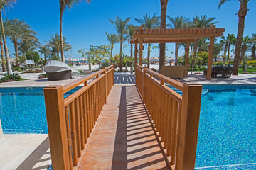 Fototapeta premium Wooden bridge over a swimming pool of luxury hotel resort room