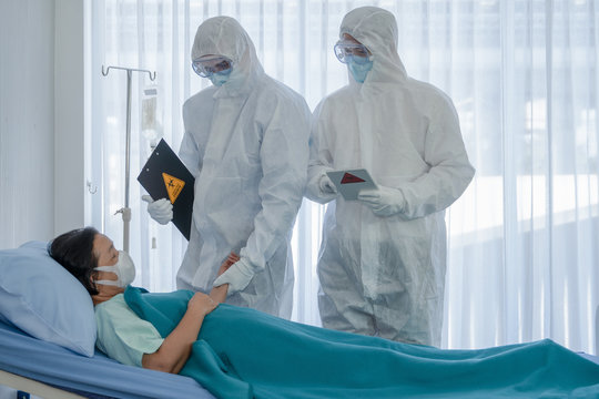 coronavirus covid 19 treatment background of coronavirus covid 19 patient on bed with doctors in PPE coverall suit in hospital negative pressure quarantine room, coronavirus covid 19 disease treatment