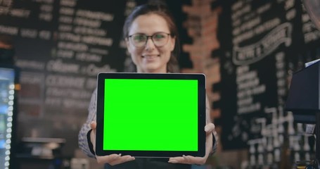Bartender shopping green screen tablet at camera and smiling