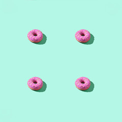 Many donuts square pattern. Set same cakes concept. Hard shadow. Top view colorful background. Green, pink colors. Unhealthy food art. Circle bright dessert