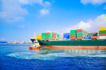 A large Container ship being gently pushed to a dock at the Haydarpasa Harbor. Tugboat, giant.