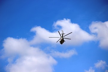 Fototapeta na wymiar helicopter in the blue sky with heap clouds.