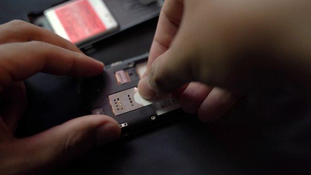 Employees are removing the Micro - sim card, given in the store for customers to buy, male hands 4K.