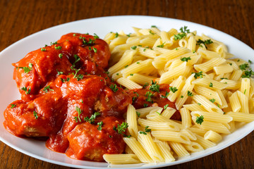 Meatballs in tomato sauce with small penne pasta