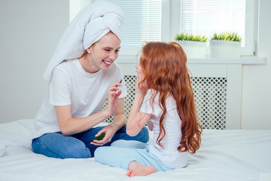 redhaired ginger woman and foxy little girl make cucumbers clay mask