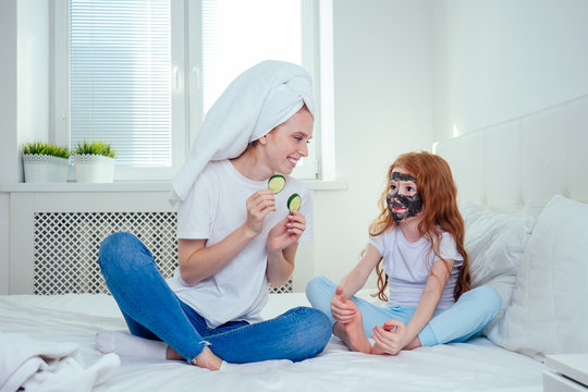 redhaired ginger woman and foxy little girl make cucumbers clay mask