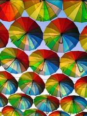 Colorful bright umbrellas are making the passers-by break into a smile.