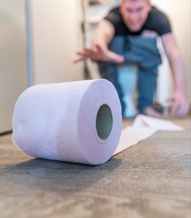 roll of toilet paper with a man in background