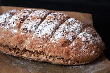 Freshly baked traditional soda bread sprinkled with flax seeds on parchment paper