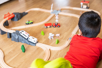 little boy plays with wooden train