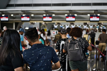 Anonymous queue of passengers in the queue waiting to arrive at the check-in desks of the airline...