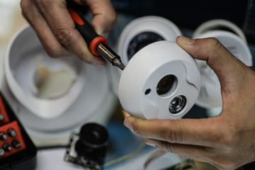technician repairs CCTV camera on the glass cabinet .