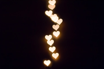 Colorful hearts bokeh on a dark background, yellow heart bokeh