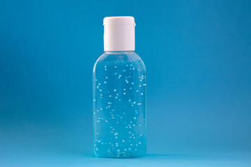 A bottle of hand sanitizer gel. Hand hygiene as coronavirus protection. Antivirus and antibacterial product. Blue liquid with white round granules. Copy space for text