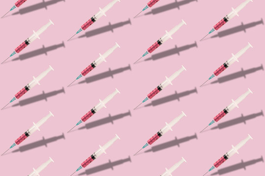 Beautiful creative pattern syringe medical on a pink background. Coronavirus concept, Protect yourself.