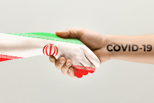 Human hands colored in flag of Iran and coronavirus - concept of spreading of virus. Hands shaking is danger, the way of wordwide epidemic. Stay safe. Prevention, safety, pandemic spread concept.