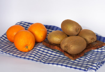 bodegon de naranjas y kiwis sobre mantel