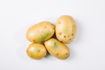 Sunlight and warmth turn potatoes skin green witch contain high levels of a toxin, solanine which can cause sickness and is poisonous. Do not buy and eat green potatoes!
