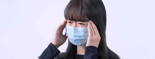 Young woman is feeling dizzy, headache, sick, unwell with wearing a medical blue face mask over the...