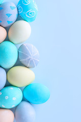 Colorful Easter hunting eggs dyed by colored water with beautiful pattern on pastel blue background, design concept of holiday, top view, copy space.