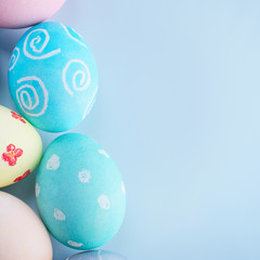 Colorful Easter hunting eggs dyed by colored water with beautiful pattern on pastel blue background, design concept of holiday, top view, copy space.