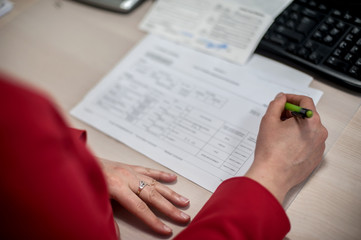 Obraz premium Close-up of female accountant hands, calculates and research the financial data position of the company and planning the economy financial profit or loss of bank accounts