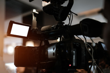 Media Television film Production Concept: Video recorder movie recording films shooting of grand opening in conference hall live event streming for presentation with blurred background by videographer