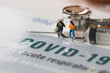 Covid-19, coronavirus outbreak disease 2019 concept: Woman traveler miniature figurine wear mask...