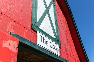 A bright red barn with a sign reading "The Coop" in black and white on the outside.