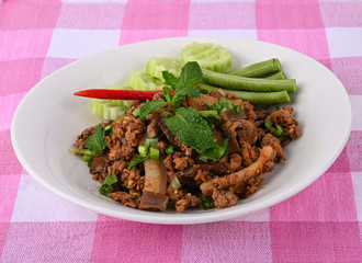 Spicy minced pork, Thai food, in a white plate on a cloth