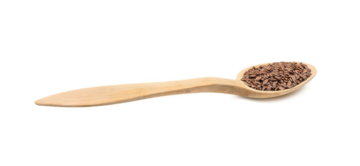 Low angle side view of linseed or flax seeds on a wood spoon and isolated on white background