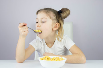 beautiful little girl at the white Breakfast cereal table