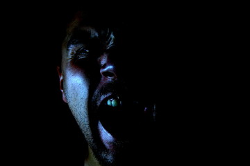 Dark horror young man scream with bloody eyes. Portrait of fear male, scary person. 