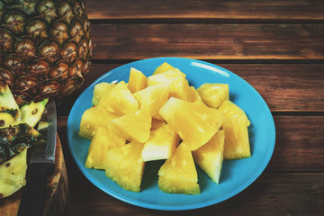 Pineapple sliced ​​in a yellow dish on wooden table