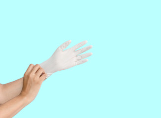 A person woman hand wearing white medication rubber glove, isolated die cut on blue background with clipping path