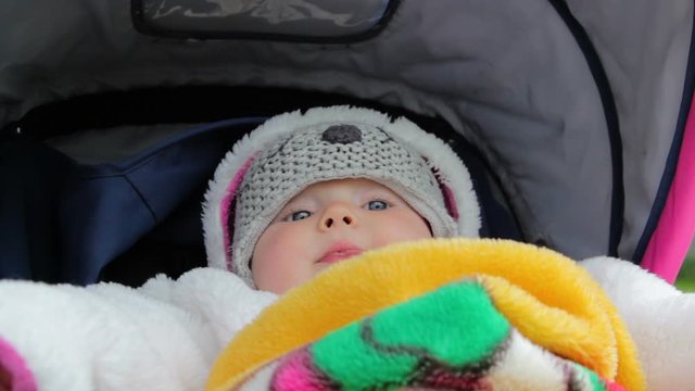 baby lies in clothes,baby on a walk lies in a stroller in the winter in a blanket