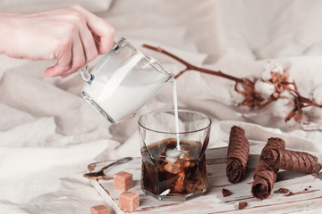 Fototapeta na wymiar Pouring cream into a glass of iced espresso.