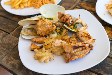 Grilled meat and burnt seafood on a plate in a restaurant