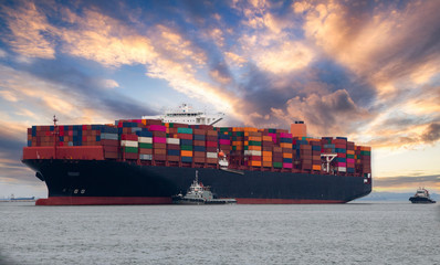 Logistics and container loading by large barges by sea in a harbor full of containers waiting to be transported