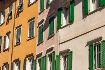 Facade of generic houses with many windows and shutters in a street in Trentino Alto Adige, Italy, Europe