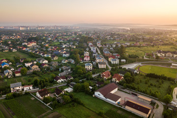 Aerial landscape of small town or village with rows of residential homes and green trees.