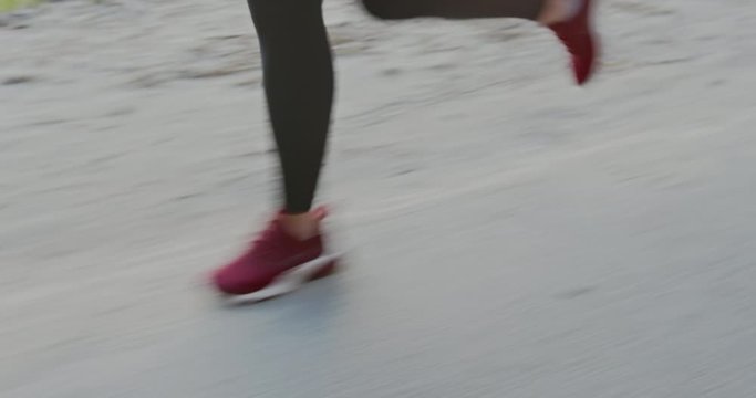 Anonymous sportswoman running on street