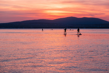 Fototapeta premium SAP surfing at sunset in Gelendzhik, Krasnodar region.