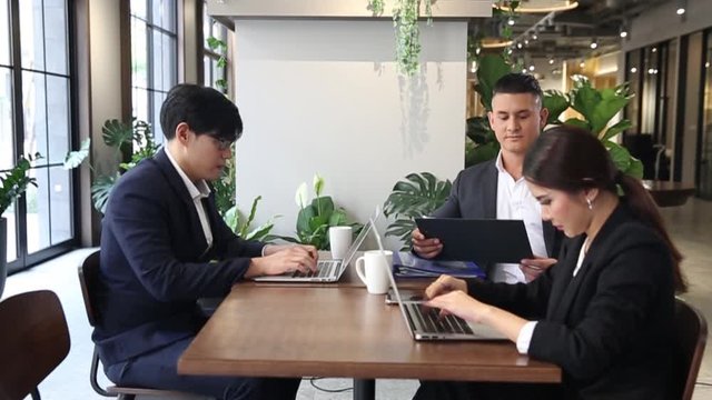 Co-working space concept. Businessman and Businesswoman is brainstroming in a co working space. Company employees are sitting in front of laptop computers.