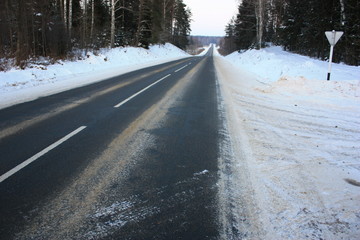 Obraz premium winter road leading into the distance, roadside signs, blizzard